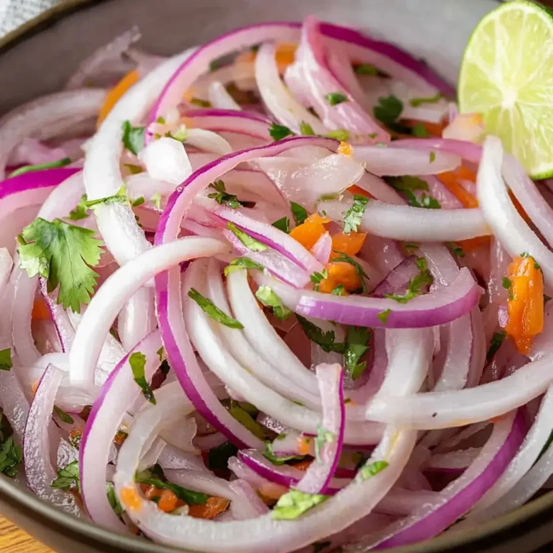 A bowl of sliced onions and carrots.