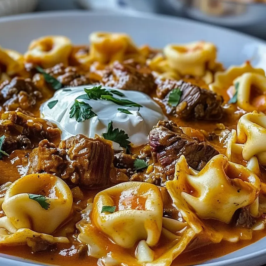 A plate of food with a cheesy beef enchilada tortellini.