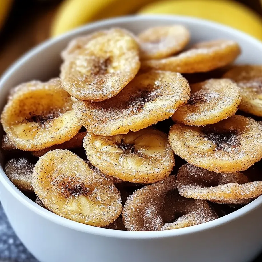 A bowl filled with banana chips coated in cinnamon sugar.