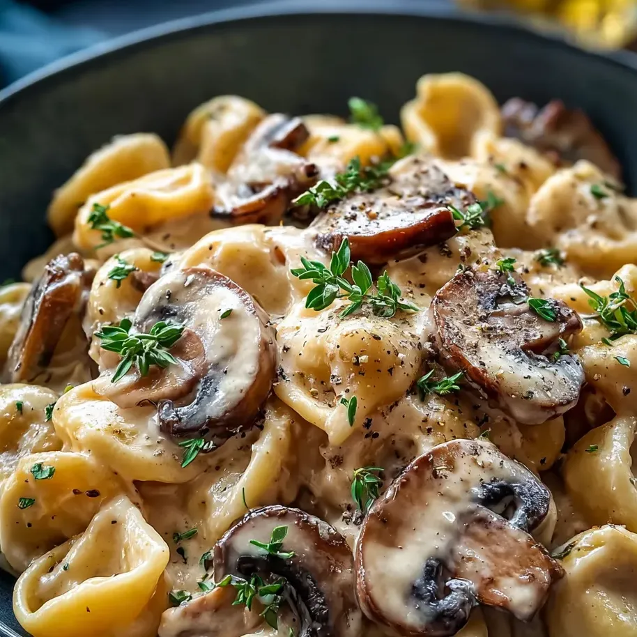 Heaping bowl of pasta bursting with mushrooms and fresh herbs.