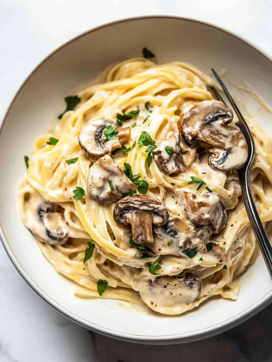 A bowl of pasta with mushrooms and herbs.