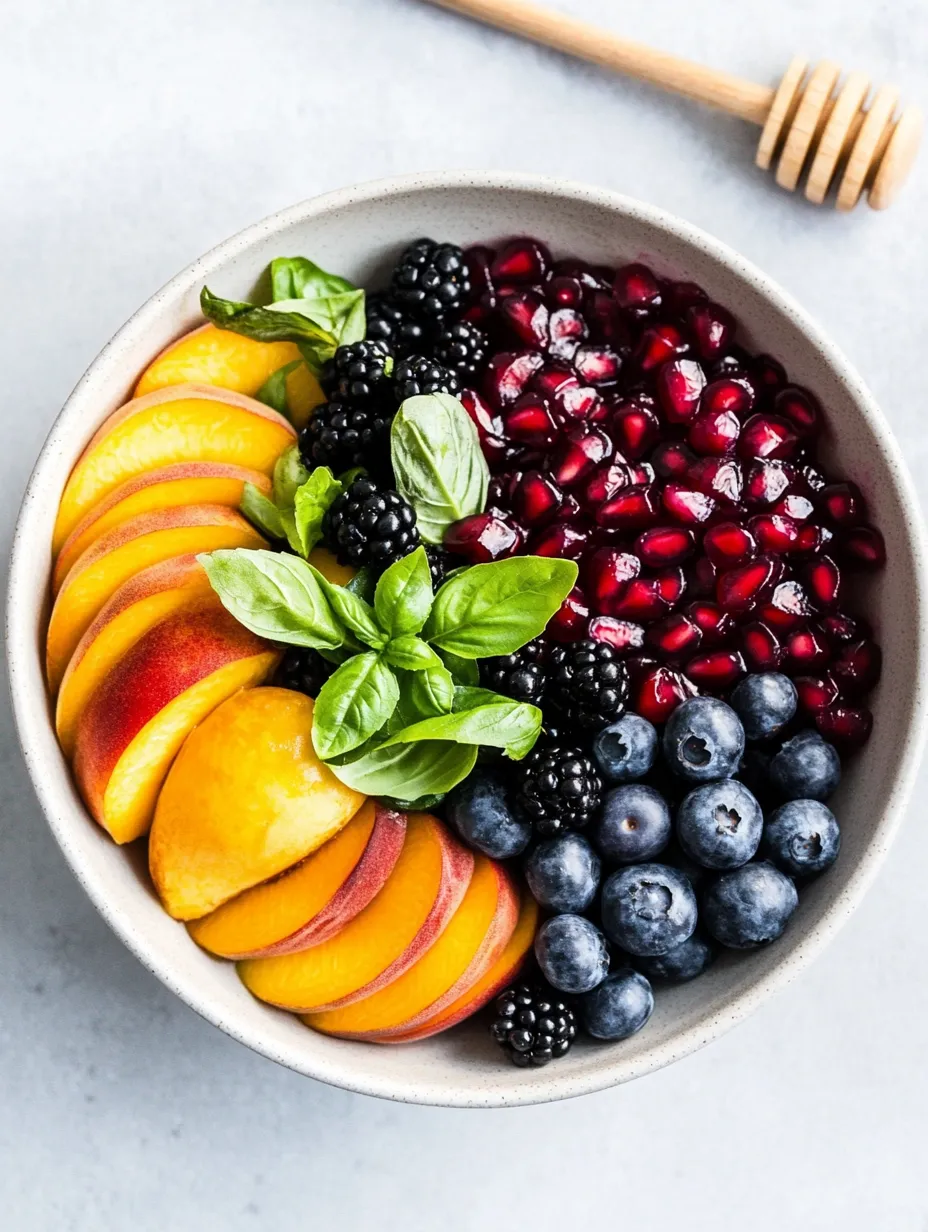 A bowl of fresh fruit—peaches, blueberries, blackberries and more.