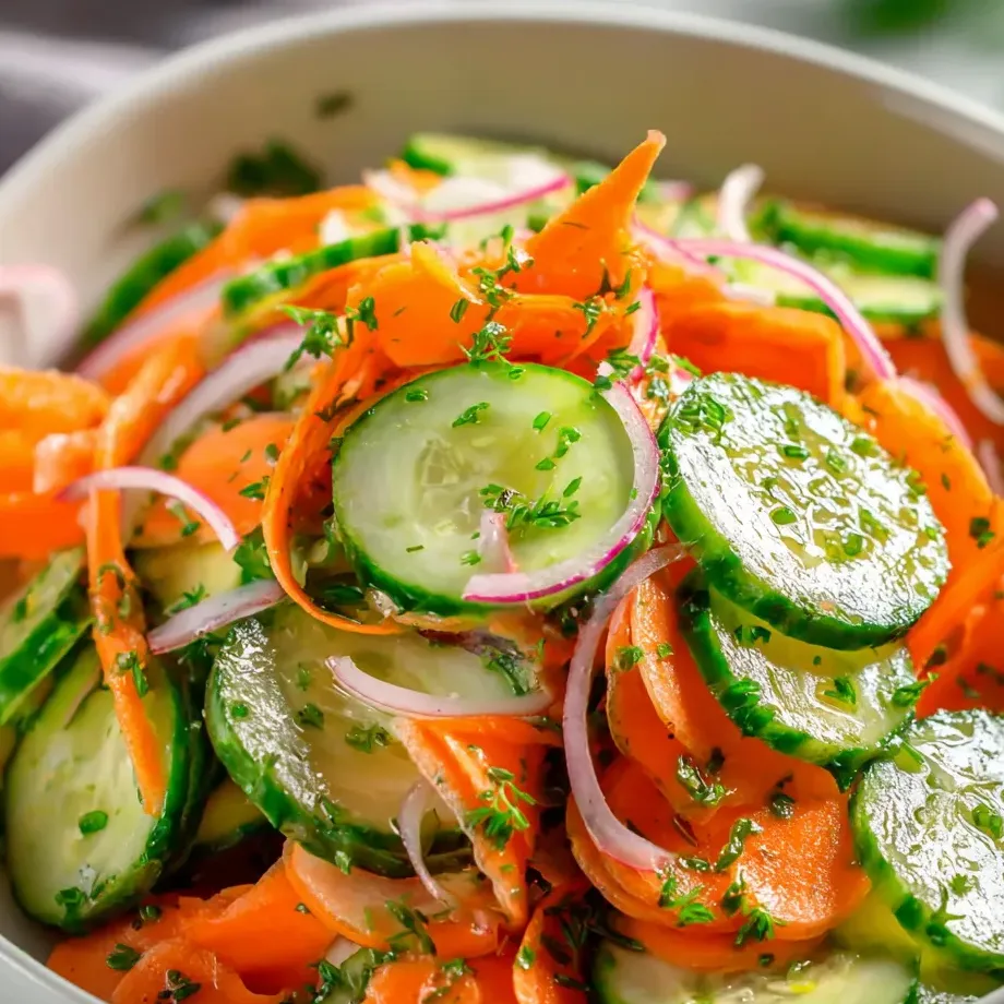A bowl packed with cucumbers, carrots, onions, and more.