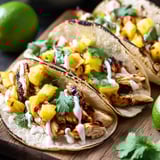 Three tacos with pineapple and chicken toppings.
