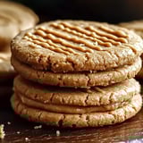 Peanut butter sandwich cookies stacked on a table.