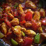 A dish of chicken and peppers in a pan.