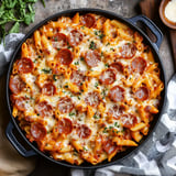 A pan of pasta with pepperoni and cheese.