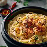 Pasta bowl loaded with chicken and red peppers.