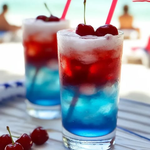 Two glasses filled with layered red, white, and blue drinks, perfect for kids' parties.