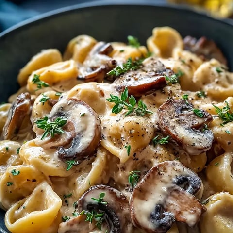 Heaping bowl of pasta bursting with mushrooms and fresh herbs.