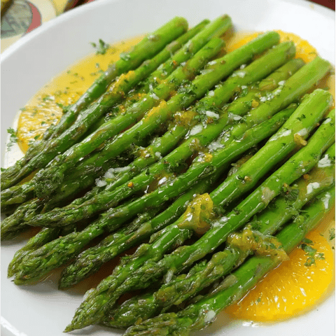 A plate of asparagus with a sauce.