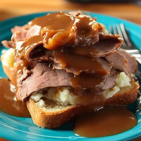 A plate piled with meat smothered in rich gravy.
