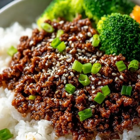 A bowl filled with beef, rice, and broccoli.